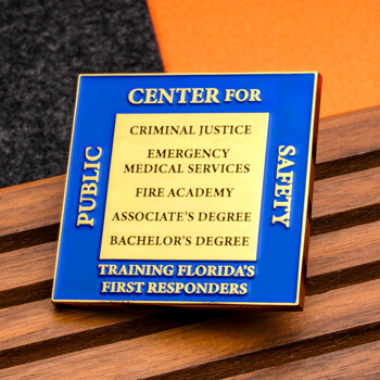 Square blue and gold lapel pin for Center for Public Safety featuring Criminal Justice and Fire Academy text.