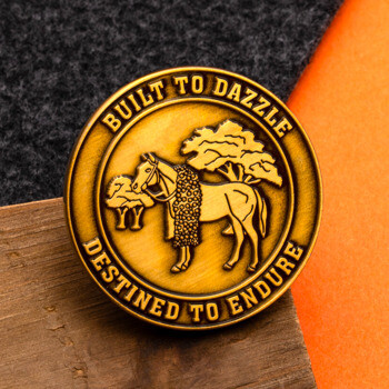 Antique gold challenge coin featuring a horse and tree design with the text Built to Dazzle, Destined to Endure.