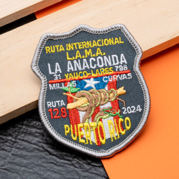 Shield-shaped embroidered patch for L.A.M.A. La Anaconda Puerto Rico 2024 featuring a snake, flag, and road map details.
