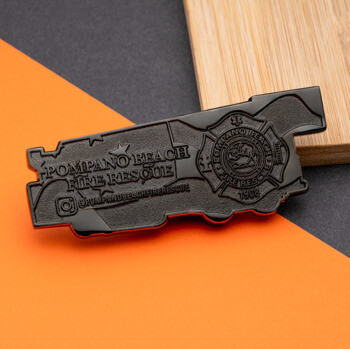 Black metal lapel pin shaped like a fire truck with the Pompano Beach Fire Rescue emblem and text.