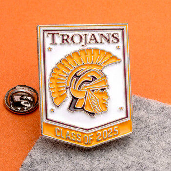 Enamel lapel pin shaped like a banner featuring a Trojan mascot helmet, marked Trojans and Class of 2025.