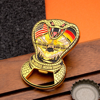 Gold cobra-shaped bottle opener challenge coin featuring 86th Aeromedical Evacuation Squadron graphics, an aircraft, and US and German flags.