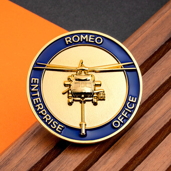 Gold and blue challenge coin featuring a raised helicopter design and Romeo Enterprise Office lettering.