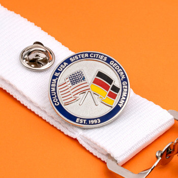 Columbia, IL USA and Gedern, Germany Sister Cities enamel lapel pin attached to a white lanyard with a metal clip.