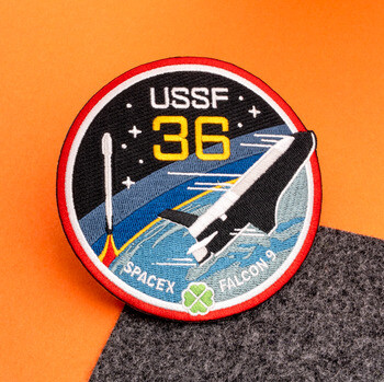 Circular embroidered patch for USSF 36 SpaceX Falcon 9 mission featuring a rocket launch and spacecraft.