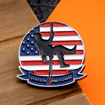 Lapel pin featuring a rappelling firefighter silhouette against an American flag with a Station 3 Midtown banner.