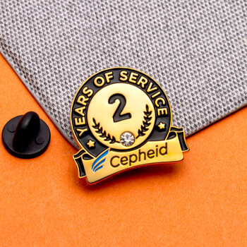 Cepheid 2 Years of Service lapel pin with gold trim, black and white enamel, rhinestone accent, and rubber clutch.
