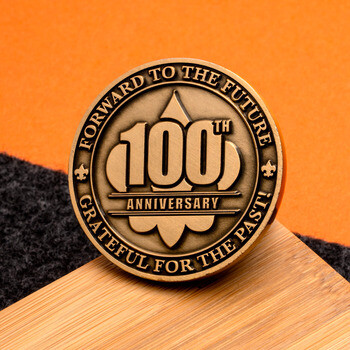 Antique brass 100th anniversary challenge coin inscribed with Forward to the Future and Grateful for the Past.