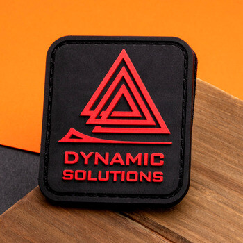 Dynamic Solutions black and red rubber PVC patch with a geometric triangle logo.
