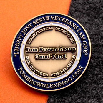 Gold and blue challenge coin for Tom Brown Group Omni-Fund with veteran motto border.