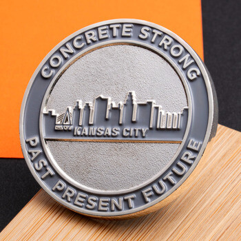 Round metallic challenge coin featuring the Kansas City skyline and text reading Concrete Strong, Past Present Future.